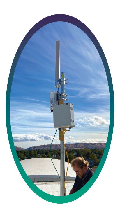 A technician works on one of Yakima School District's WiFi signal boosters.