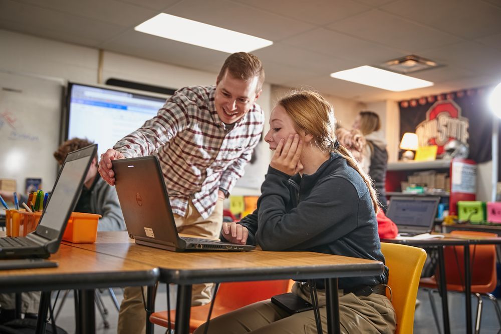 Student and teacher have a conversation in a Grant Career Center classroom.