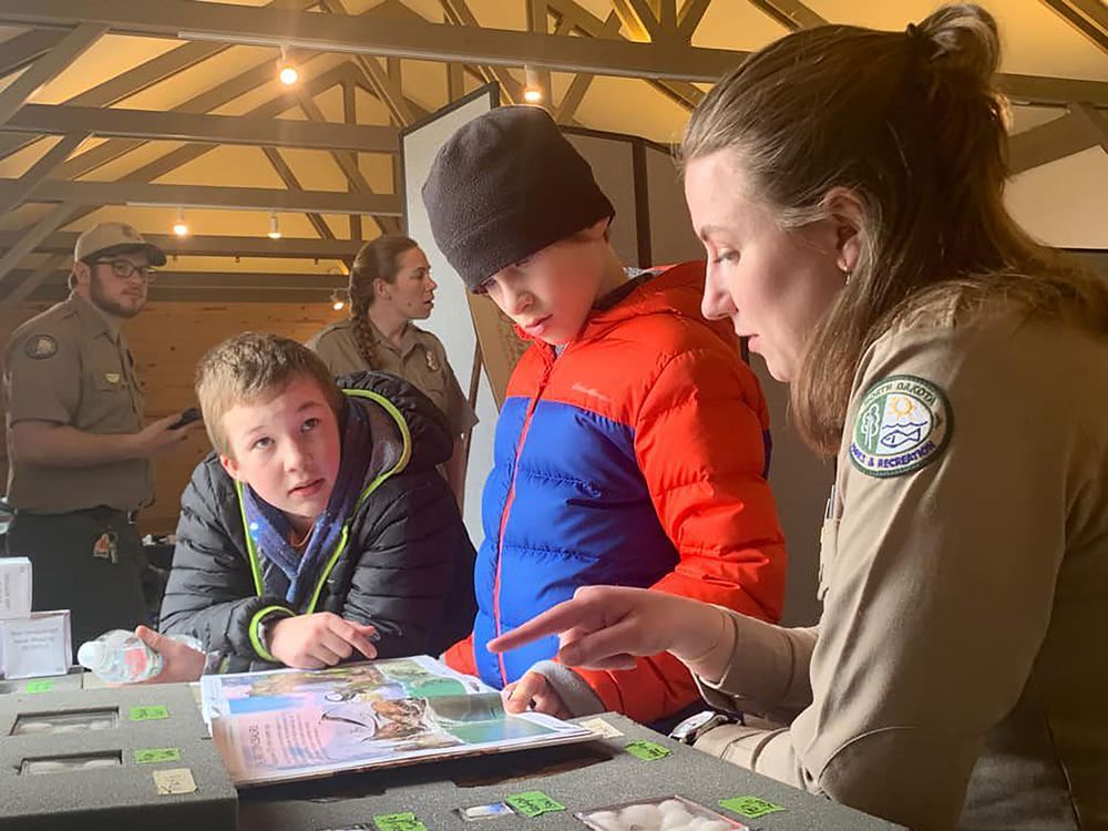 Two students look at geological map with female park ranger