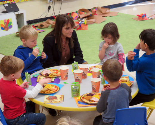 Dr. Morillo sitting with young students