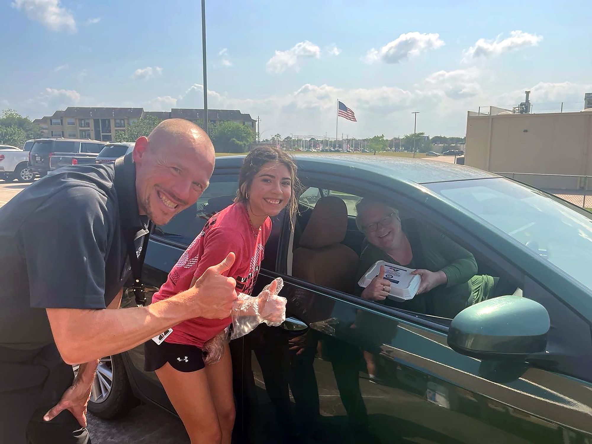 Photograph of Dr. Quintin Shepherd holding thumbs up next to student and parent.