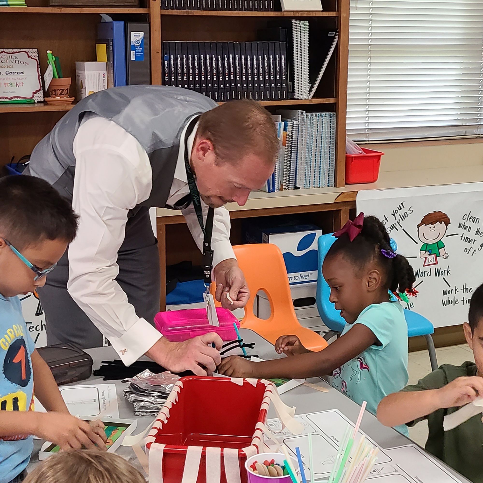 A photograph of Dr. Quintin Shepherd helping students in classroom. 