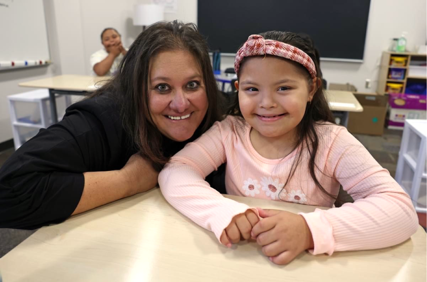 Photograph of Dr. Birhanzel smiling with young student in classroom