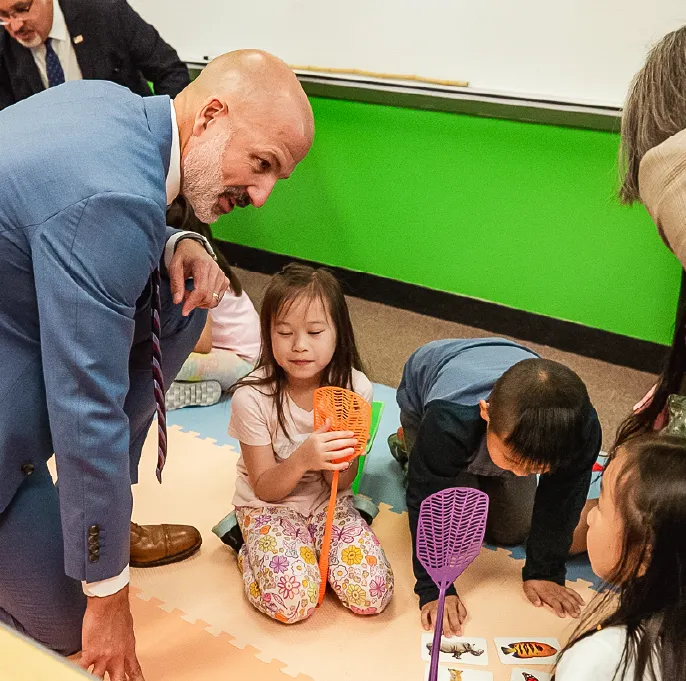 Photograph of Dr. Joe Gothard with elementary students 