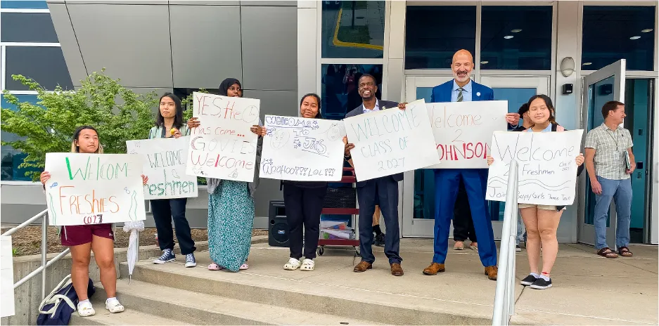 Photograph of Dr. Joe Gothard with students holding "Welcome Freshmen" signs