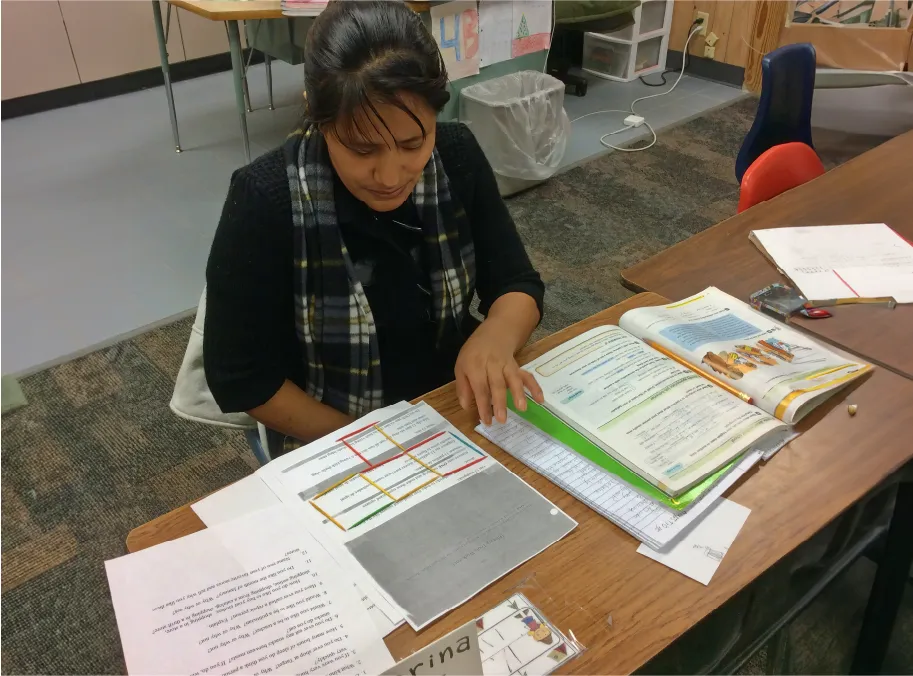 A young woman in a scarf reviews adult education materials 
